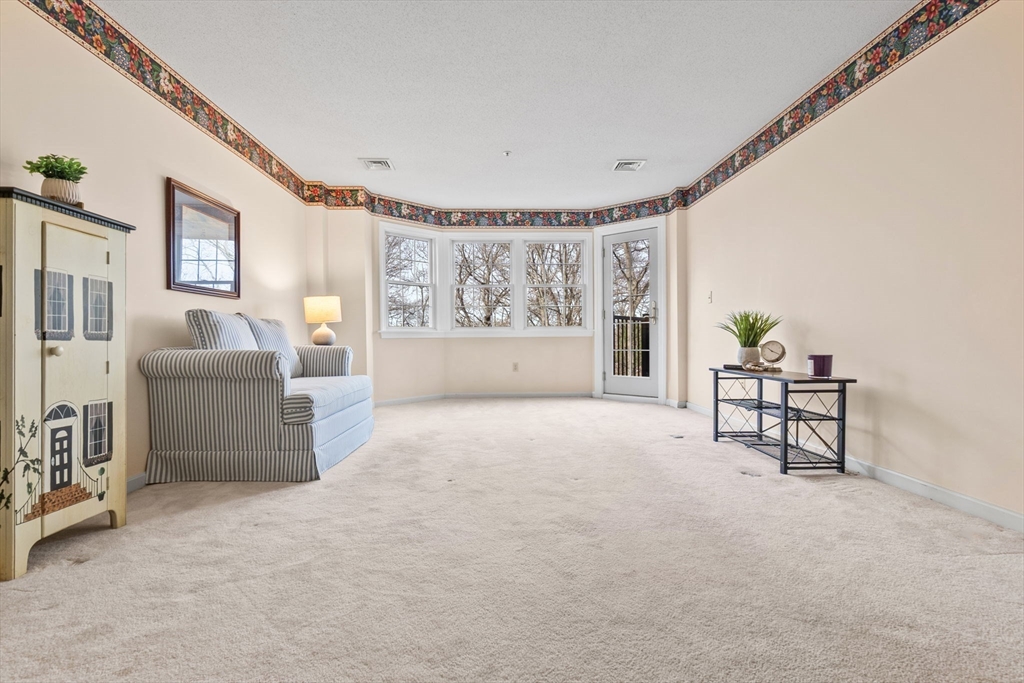 148 Main Street, Unit C538 North Andover, MA 01845 - Photo 9 of 23 a living room with furniture and a large window