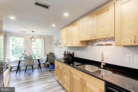 a kitchen with granite countertop a sink a counter space appliances and cabinets