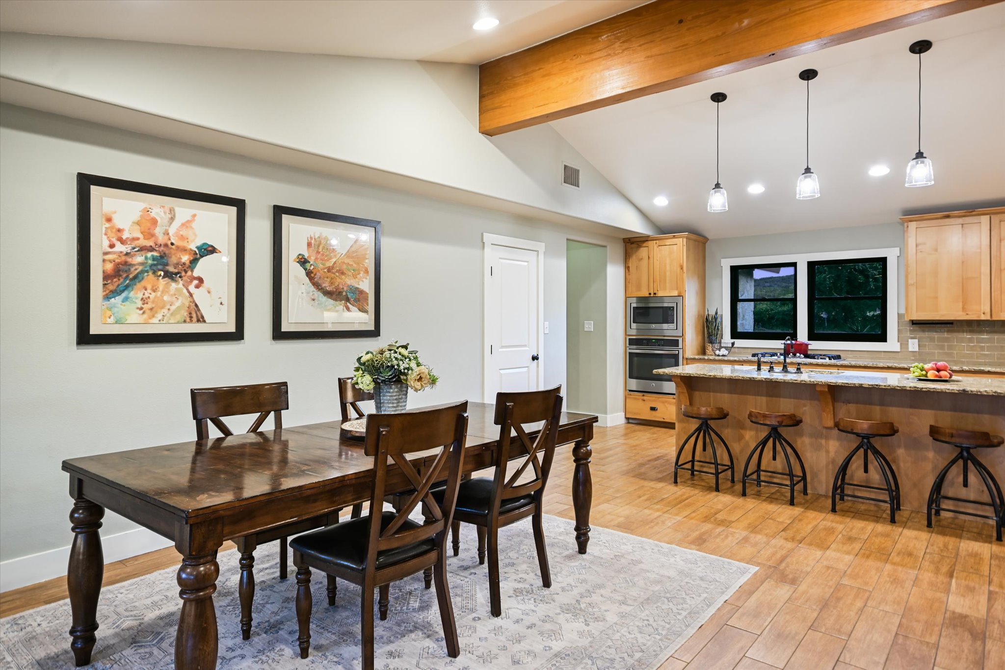 2411 Spoke Hollow Road Wimberley, TX 78676 - Photo 9 of 37 An open-concept design with vaulted ceilings merges dining and kitchen areas for seamless entertaining.