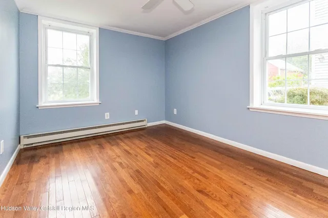 a view of a room with wooden floor and a window