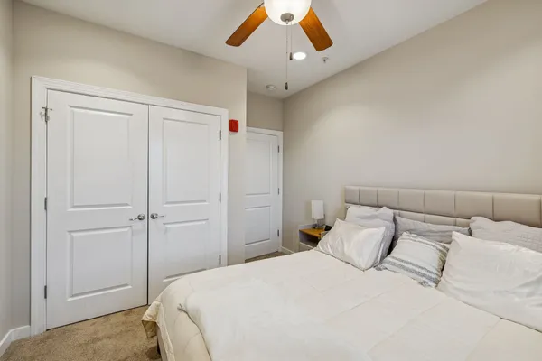 a bedroom with a large bed and a chandelier