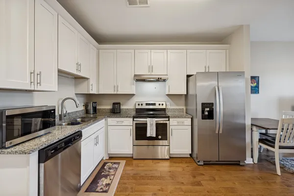 a kitchen with stainless steel appliances granite countertop a stove a refrigerator and a granite counter tops