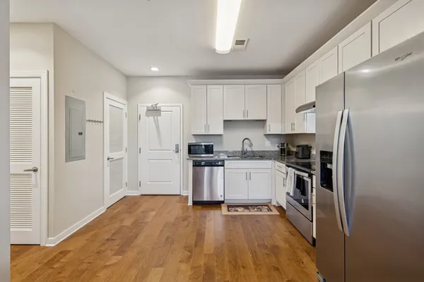 a kitchen with a refrigerator a sink and a stove top oven