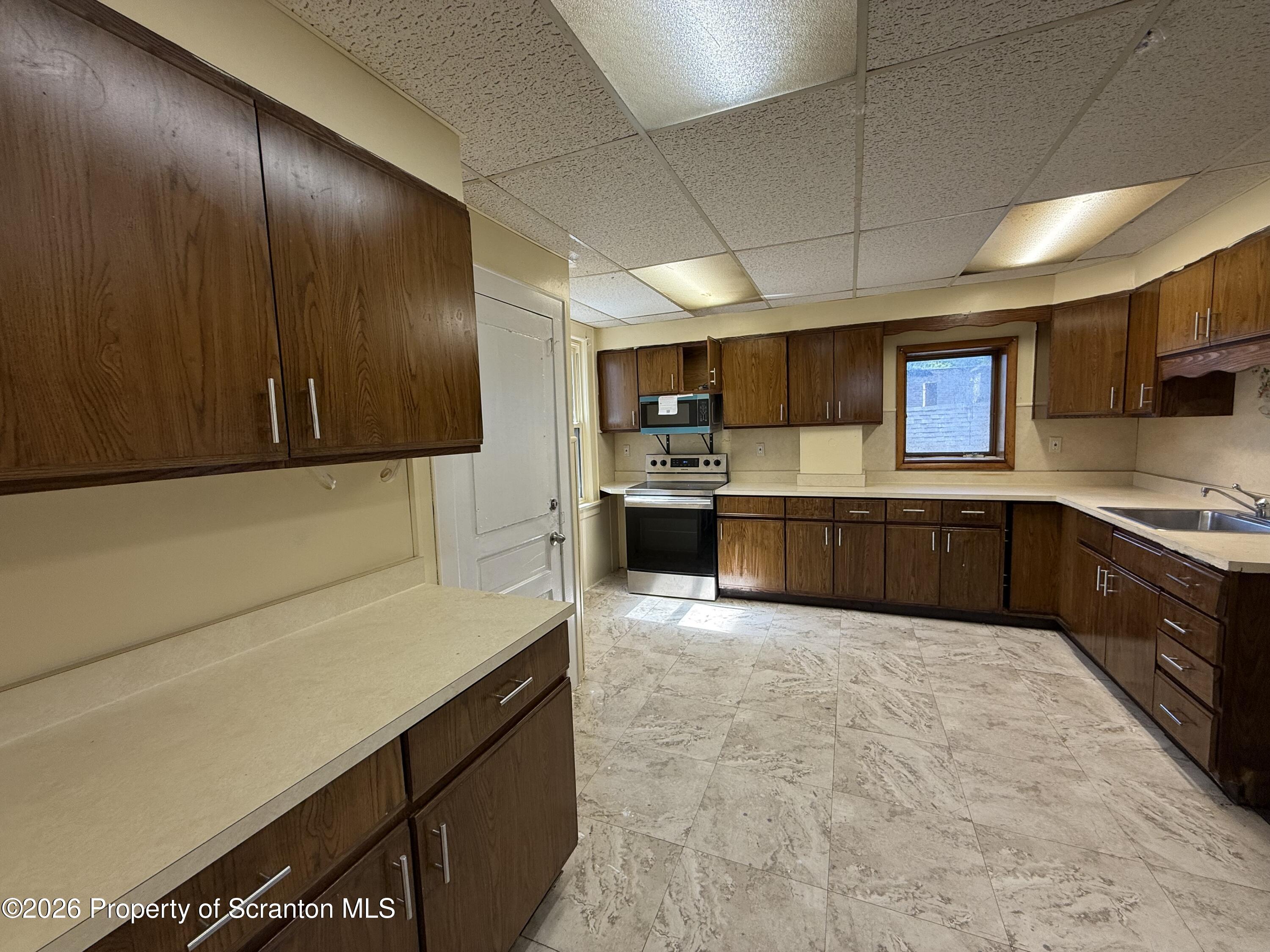 1706 Prospect Avenue, Unit 2 Scranton, PA 18505 - Photo 3 of 16 a large kitchen with stainless steel appliances wooden cabinets a stove and a refrigerator