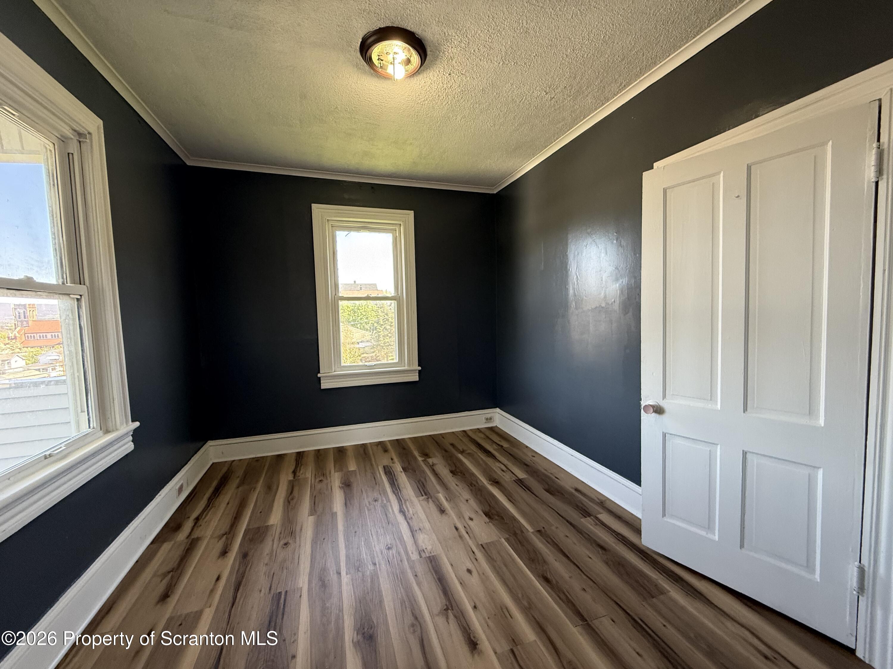 1706 Prospect Avenue, Unit 2 Scranton, PA 18505 - Photo 10 of 16 an empty room with wooden floor and windows
