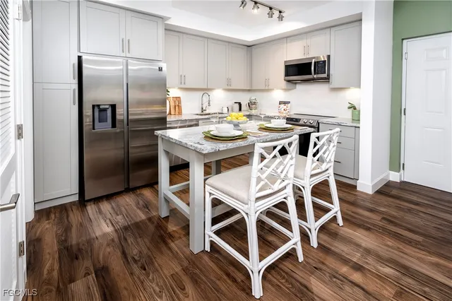 a kitchen with a table chairs refrigerator and microwave