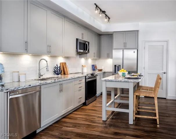a kitchen with a sink cabinets and wooden floor