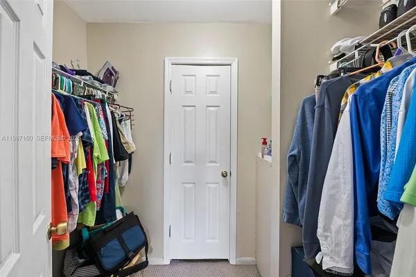 a view of walk in closet with clothes