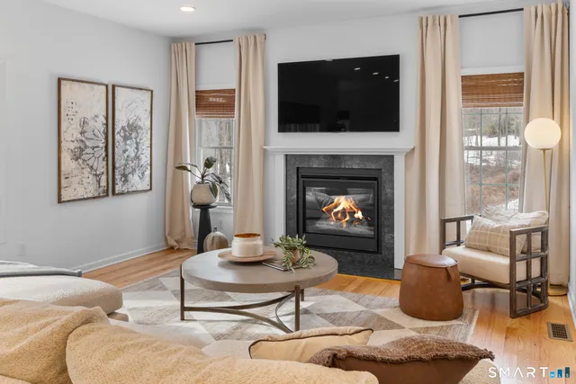 a living room with furniture a flat screen tv and a fireplace