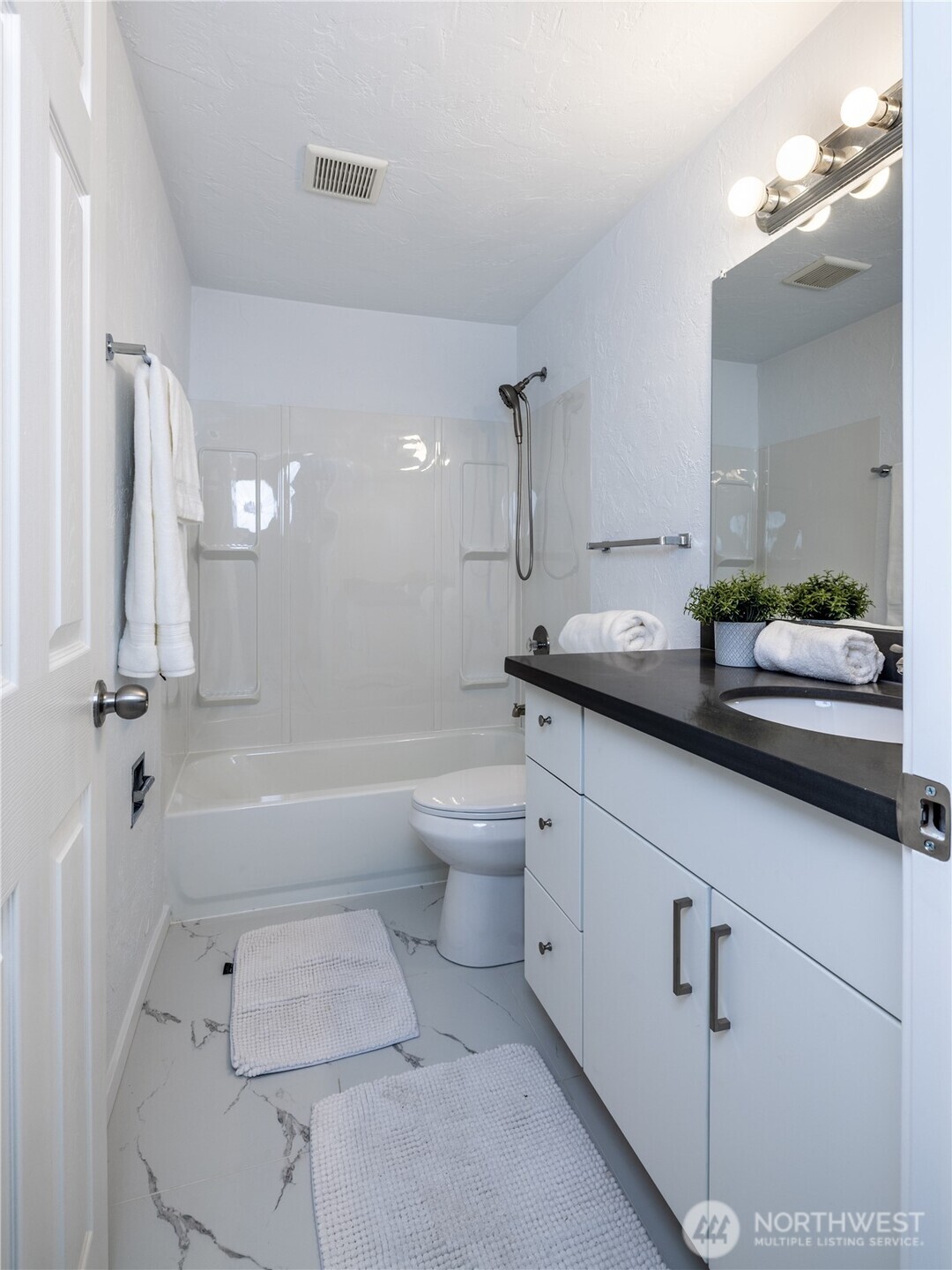 2100 North 106th Street, Unit 307 Seattle, WA 98133 - Photo 6 of 11 a bathroom with a granite countertop sink a toilet and bathtub
