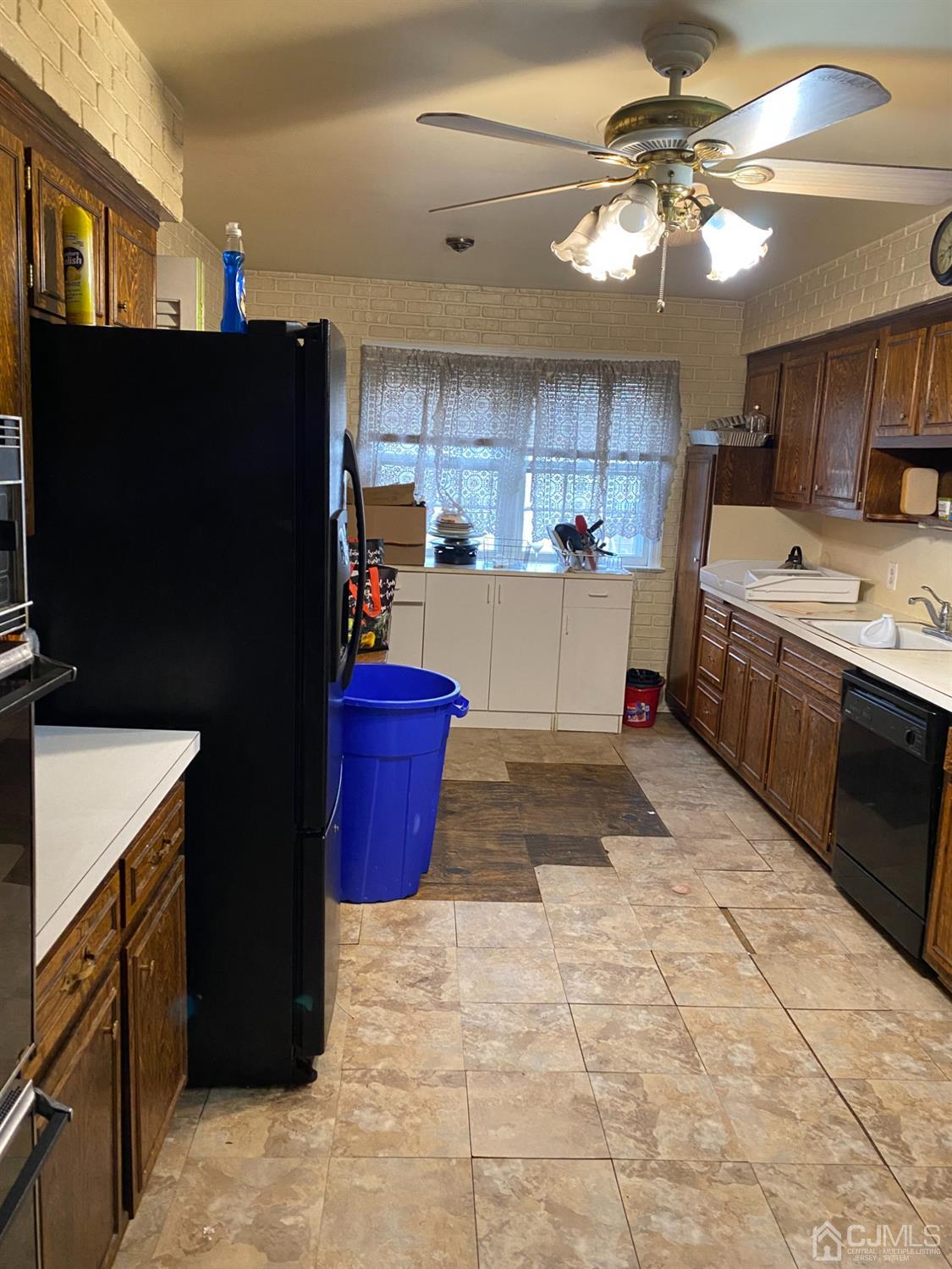 230 Austin Road Orange, NJ 07050 - Photo 12 of 34 a kitchen with kitchen island granite countertop a refrigerator a sink dishwasher and a stove with wooden cabinets
