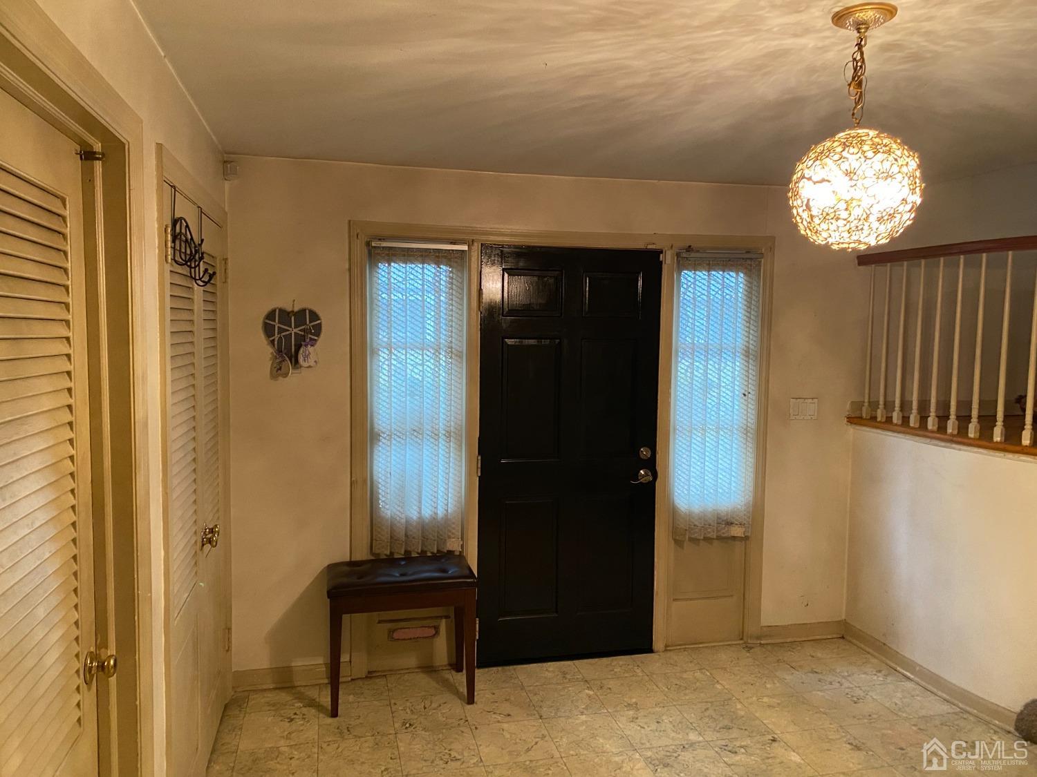 230 Austin Road Orange, NJ 07050 - Photo 7 of 34 a view of a hallway with wooden floor and a chandelier
