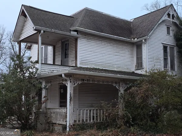 a view of a house with wooden walls and potted plants