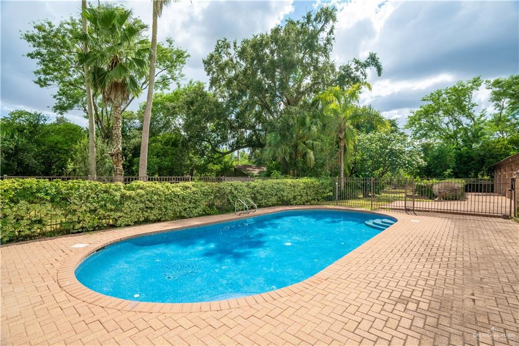 1131 West 6th Street Weslaco, TX 78596 - Photo 30 of 45 a view of a swimming pool with a yard and trees
