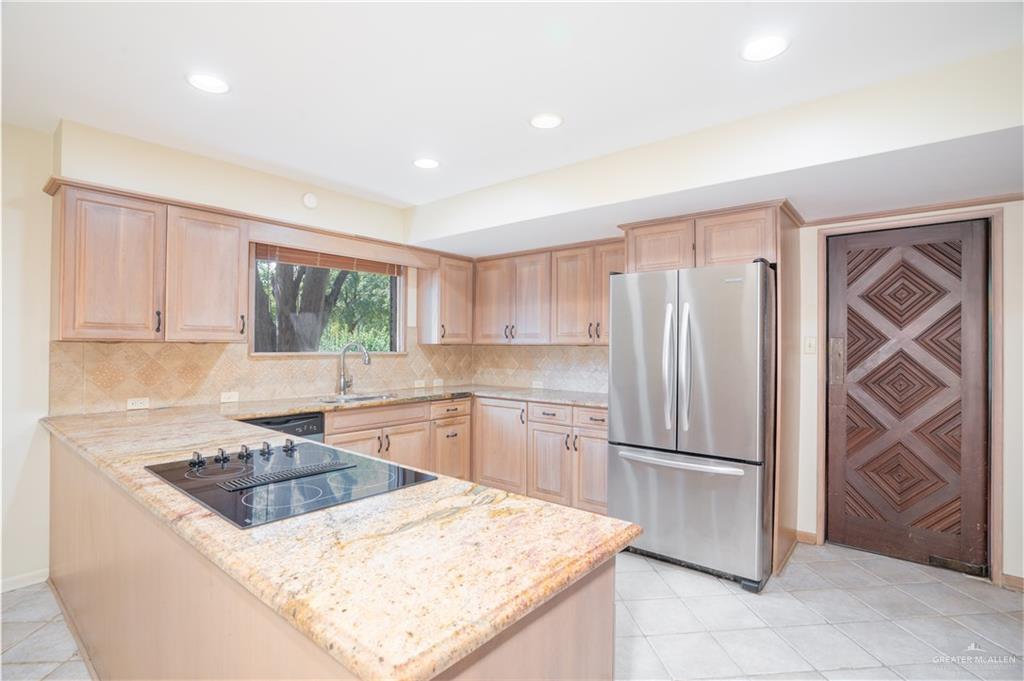 1131 West 6th Street Weslaco, TX 78596 - Photo 6 of 45 a kitchen with a stove a sink and a refrigerator
