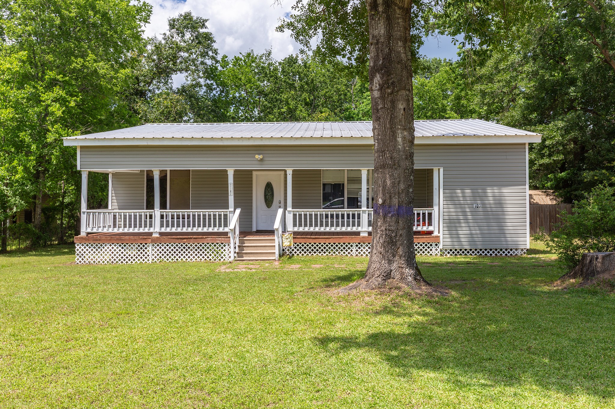a view of house with backyard and a large tree