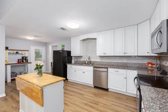 a kitchen with granite countertop cabinets and refrigerator