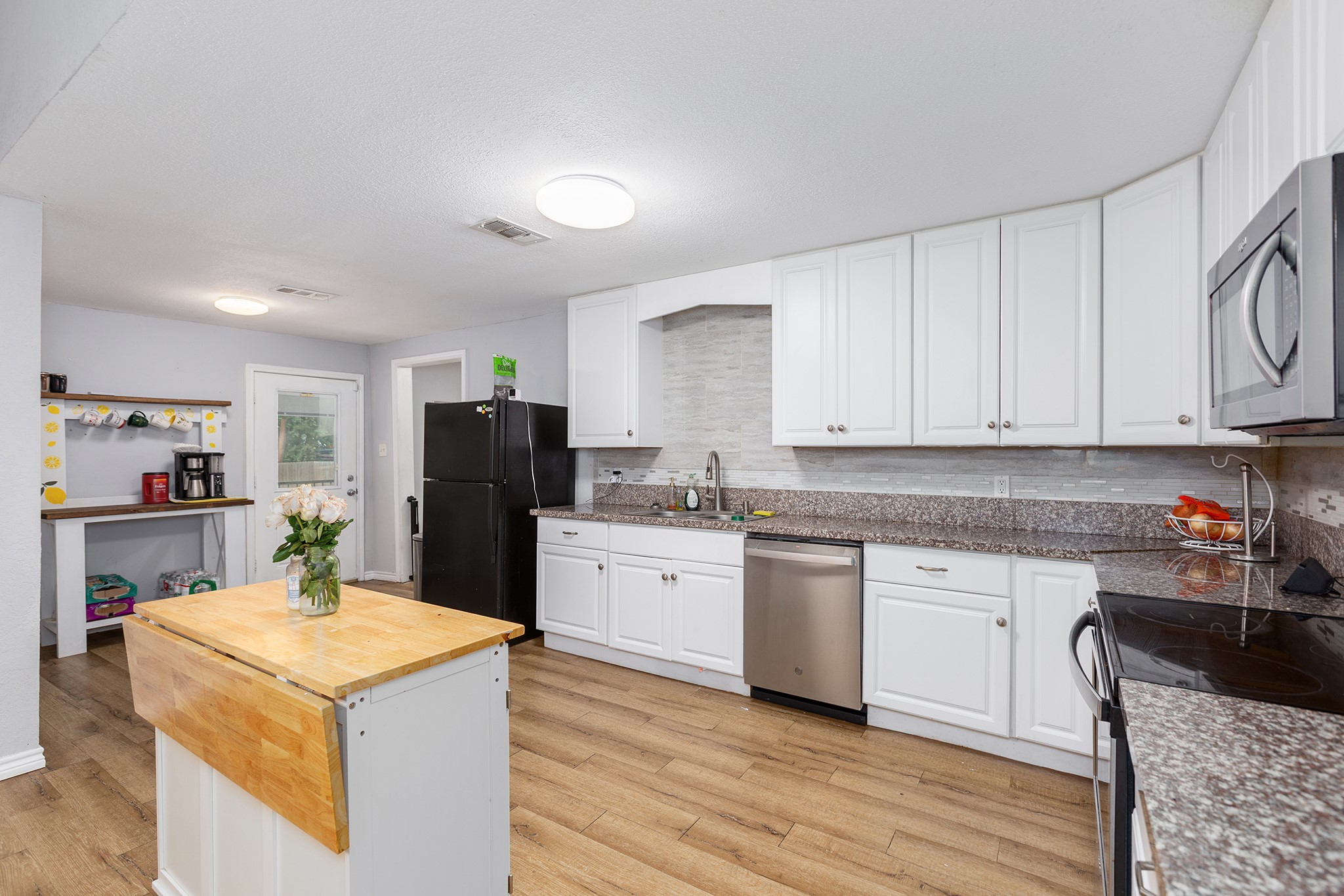 240 North 7th Street Trinity, TX 75862 - Photo 19 of 32 a kitchen with granite countertop cabinets and refrigerator