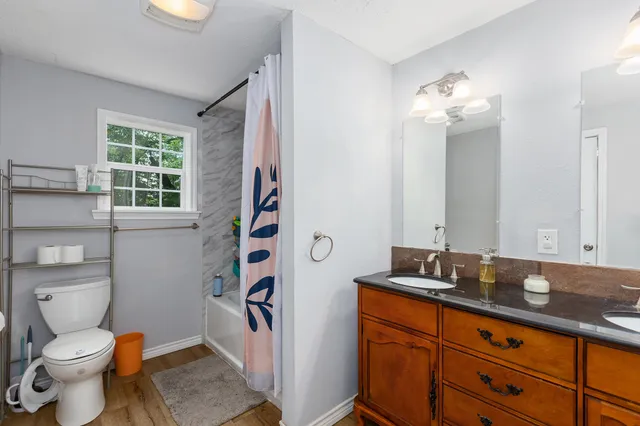 a bathroom with a granite countertop toilet sink and mirror