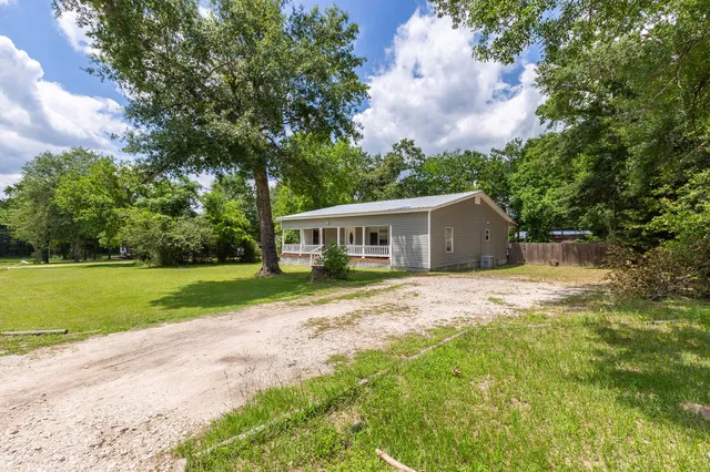 a front view of a house with yard and green space