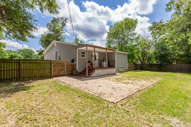 a view of a white house with wooden fence