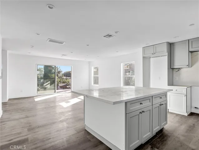 a room with a sink cabinets and wooden floor