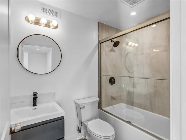 a large white kitchen with a stove a sink dishwasher and a refrigerator with wooden floor