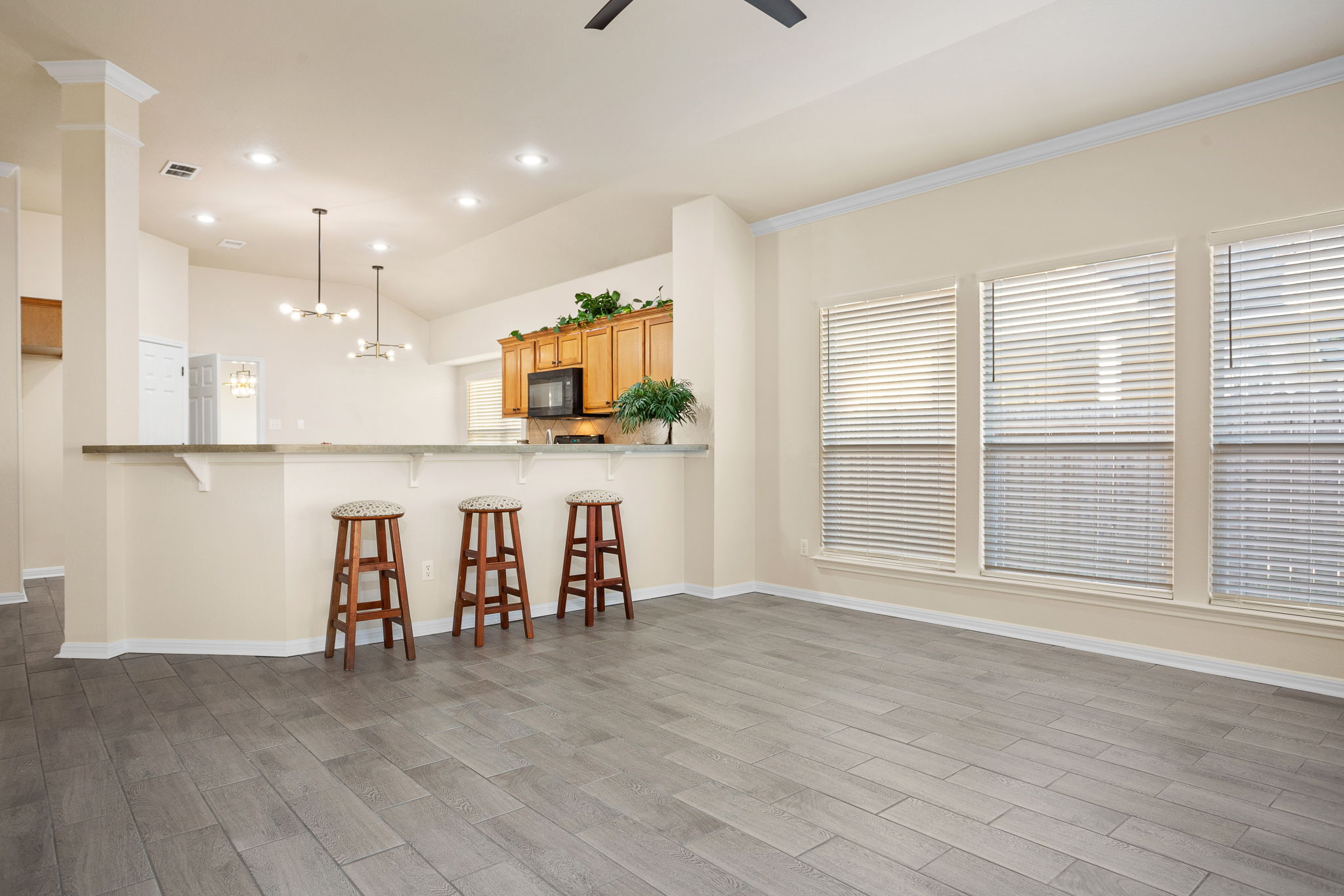 313 Greenside Lane Georgetown, TX 78633 - Photo 20 of 40 Kitchen featuring a breakfast bar, light wood-style floors, a peninsula, a ceiling fan, and lofted ceiling