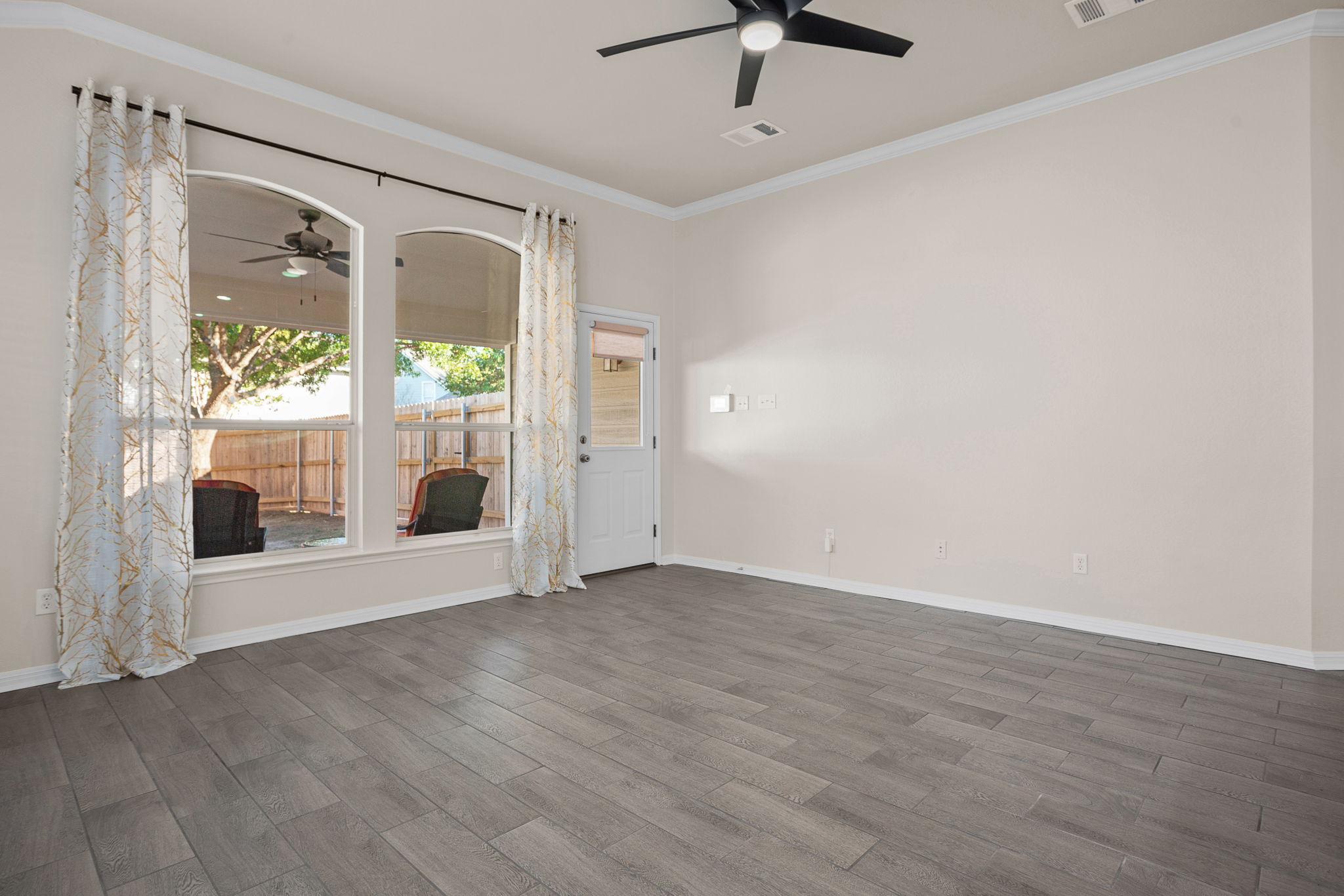 313 Greenside Lane Georgetown, TX 78633 - Photo 25 of 40 Unfurnished room featuring a ceiling fan, crown molding, and dark wood-style flooring