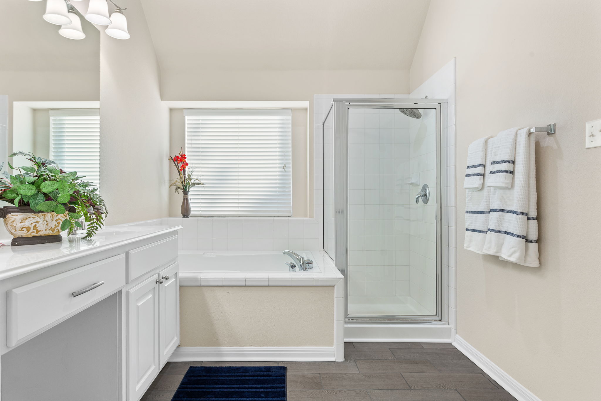 313 Greenside Lane Georgetown, TX 78633 - Photo 30 of 40 Bathroom featuring vanity, a shower stall, a garden tub, dark wood-type flooring, and lofted ceiling