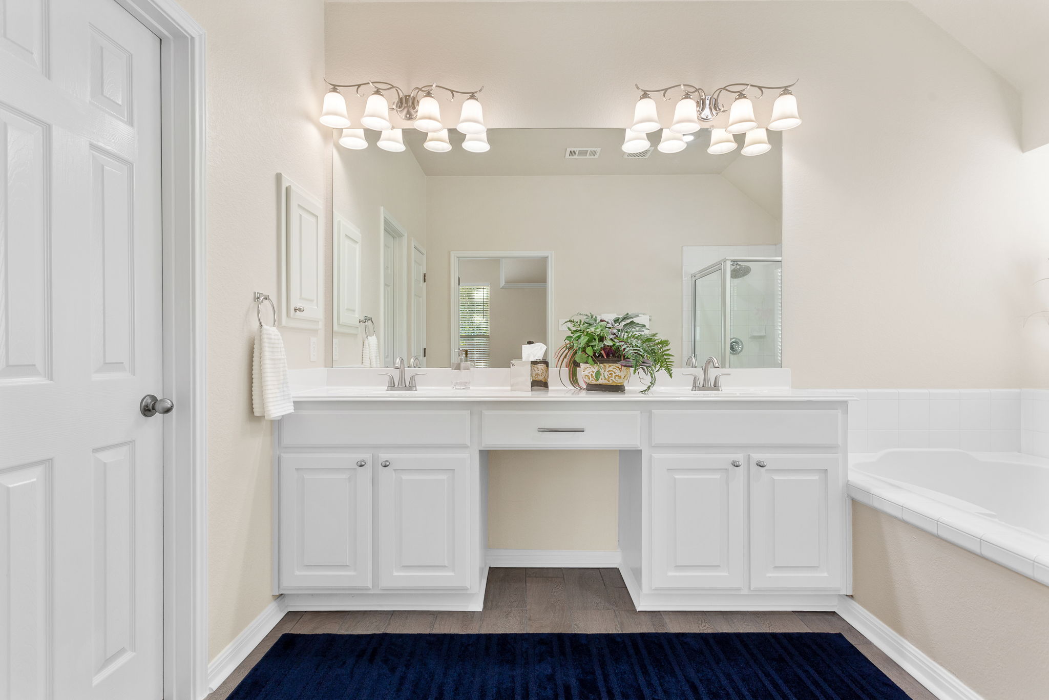 313 Greenside Lane Georgetown, TX 78633 - Photo 34 of 40 Bathroom featuring double vanity, a stall shower, a bath, and dark wood finished floors