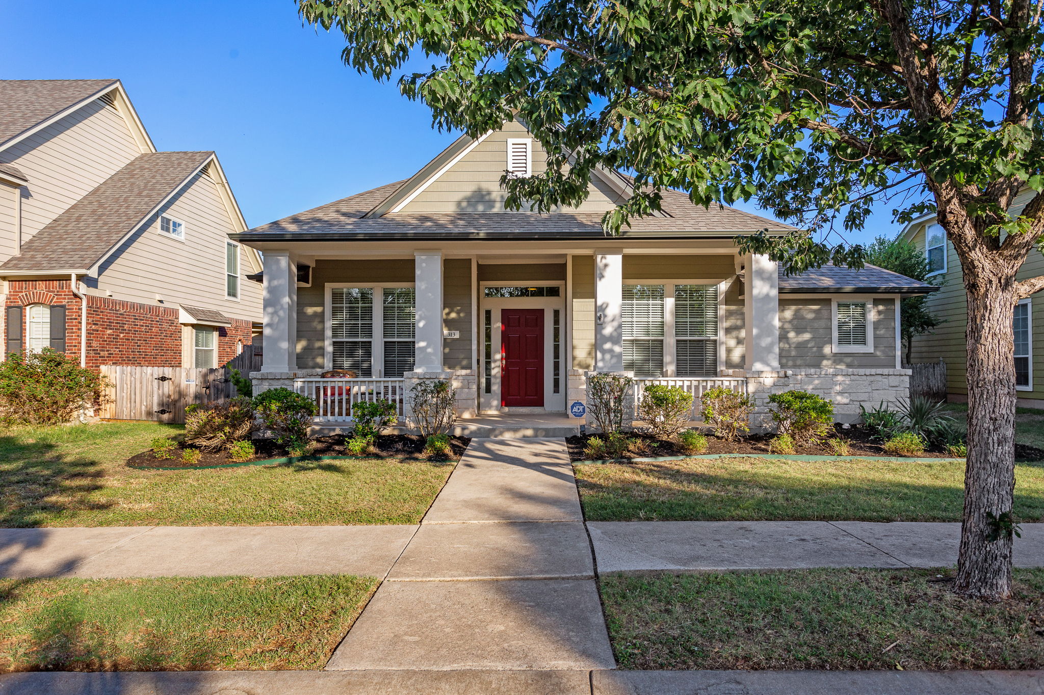 313 Greenside Lane Georgetown, TX 78633 - Photo 8 of 40 Bungalow-style house featuring covered porch, roof with shingles, a front lawn, and brick siding