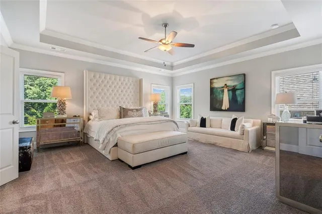 a spacious bedroom with a bed and a flat screen tv