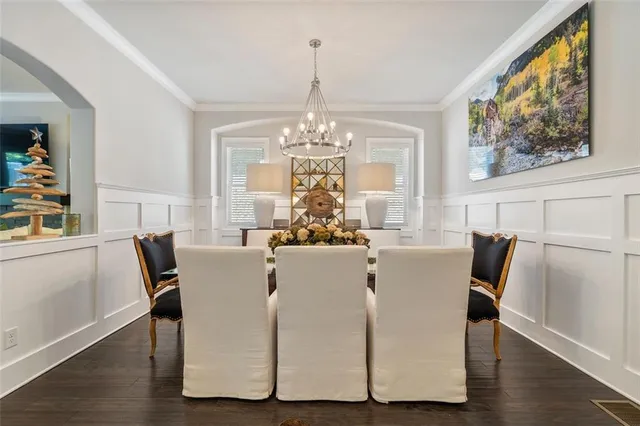 a dining room with furniture a large window and wooden floor