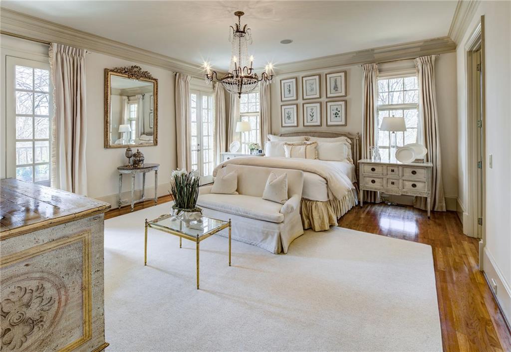 1005 Heards Ferry Road Northwest Sandy Springs, GA 30328 - Photo 7 of 30 a spacious bedroom with a bed and a chandelier