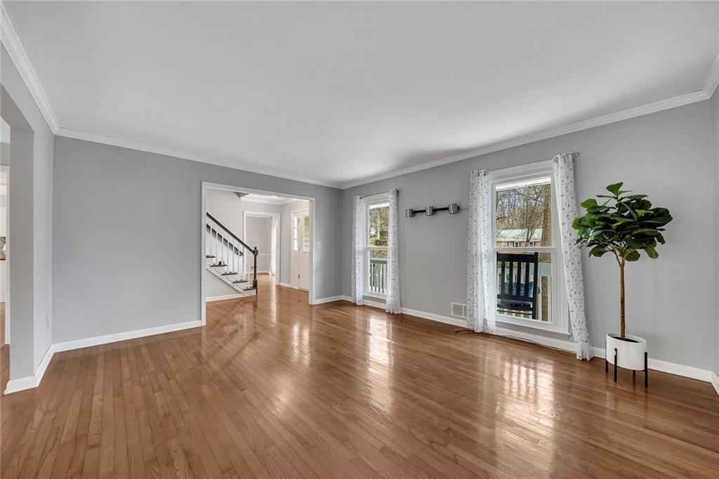 507 Spring Creek Way Northeast Marietta, GA 30068 - Photo 10 of 50 a view of an empty room with a potted plant and wooden floor