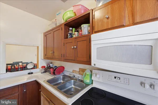 a kitchen with kitchen island a sink dishwasher stove and microwave with wooden floor