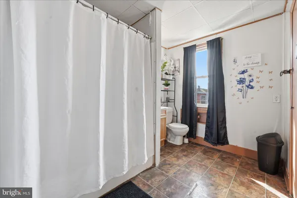 a bathroom with a granite countertop shower and a toilet