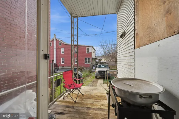 a view of balcony with wooden furniture and outdoor seating