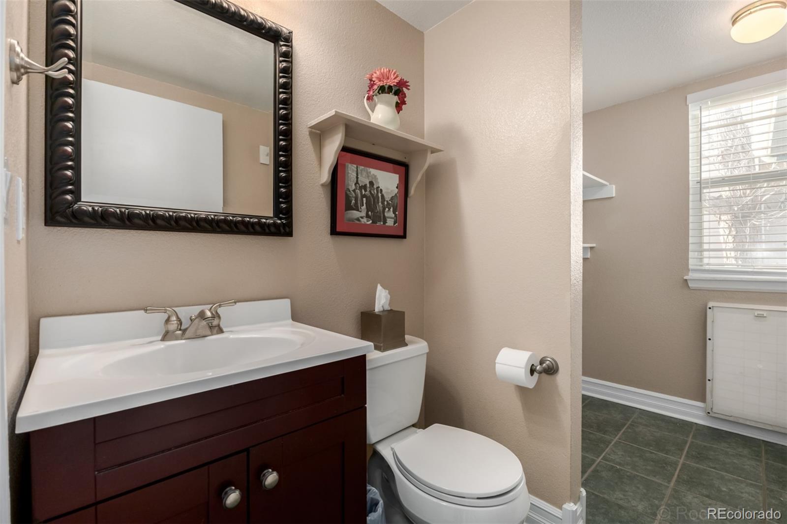 8894 Miners Street Highlands Ranch, CO 80126 - Photo 15 of 41 a bathroom with a toilet a sink and mirror