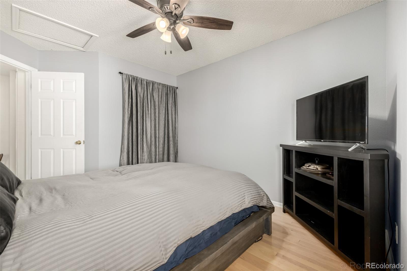 8894 Miners Street Highlands Ranch, CO 80126 - Photo 21 of 41 a bedroom with a bed and a flat tv screen