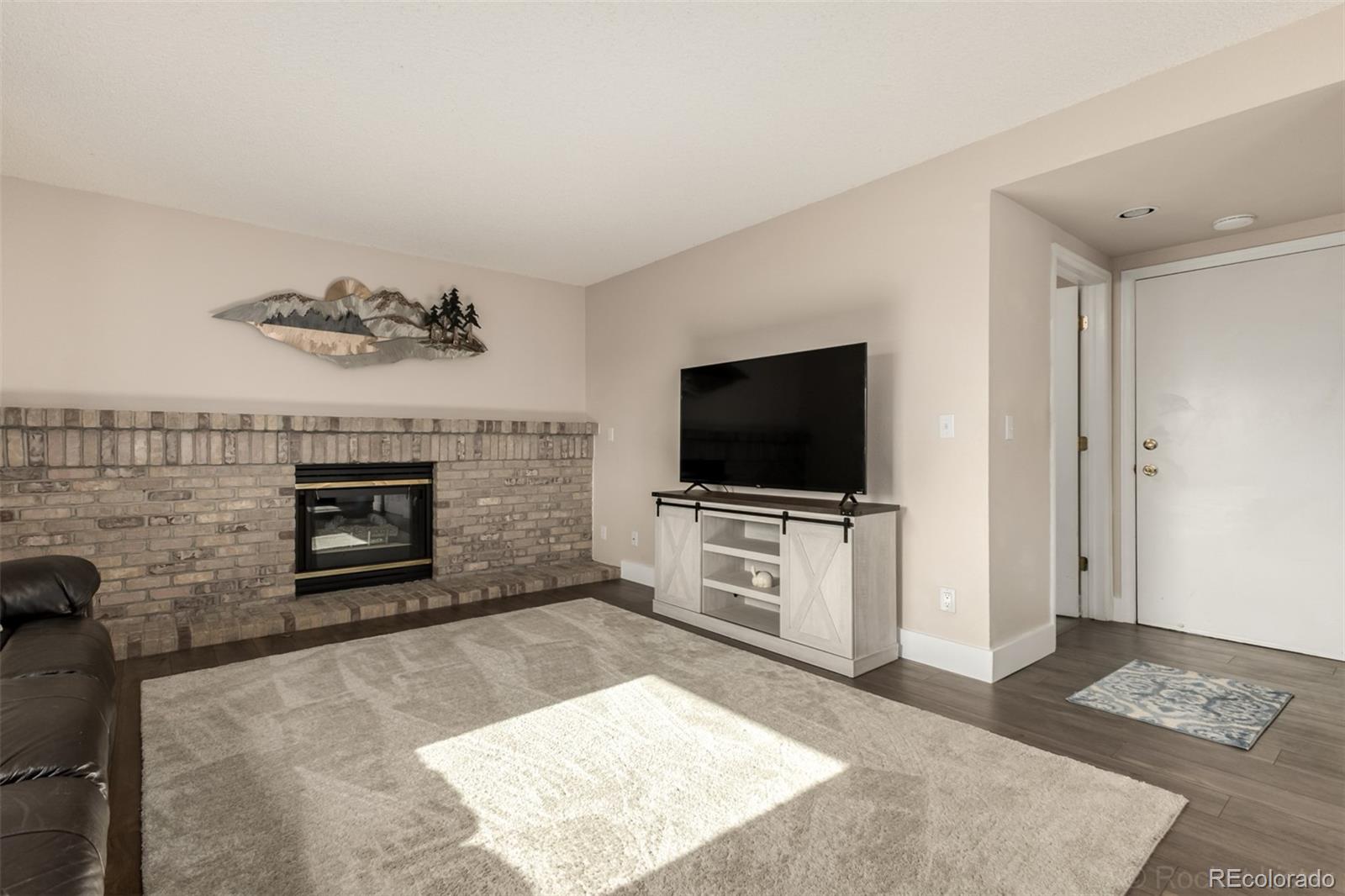 8894 Miners Street Highlands Ranch, CO 80126 - Photo 8 of 41 a living room with furniture a flat screen tv and a fireplace