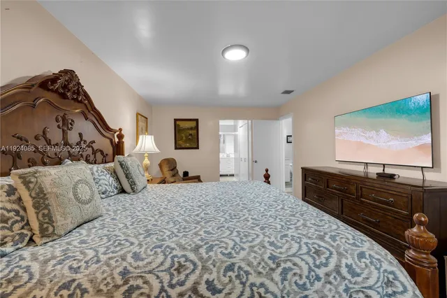 a large bedroom with a bed and a flat screen television
