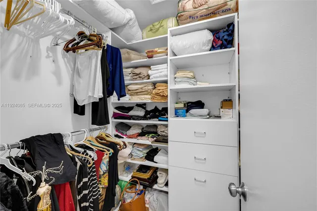 a view of walk in closet with clothes and shoes