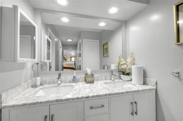 a bathroom with a granite countertop sink and a mirror