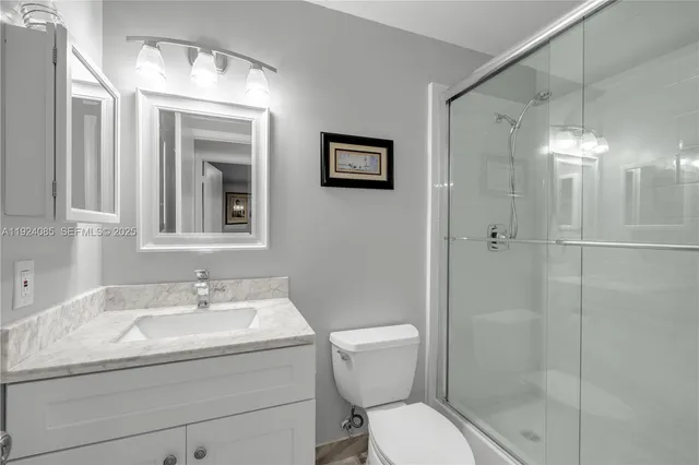 a bathroom with a toilet sink shower and mirror