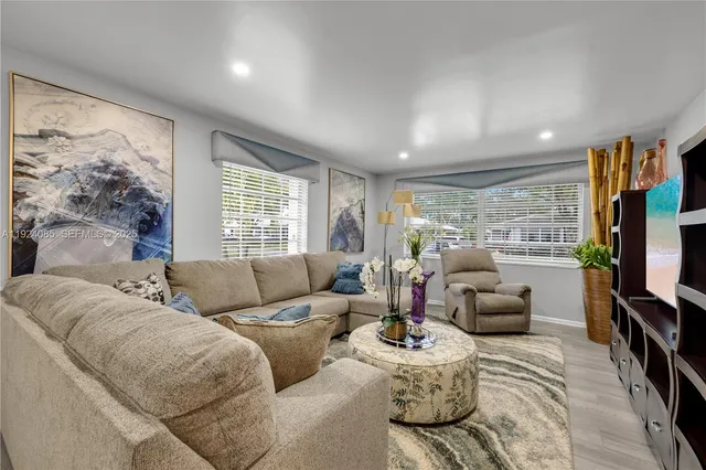 a living room with furniture flat screen tv and a large window