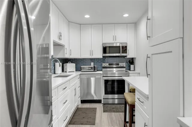 a kitchen with stainless steel appliances a refrigerator sink and microwave