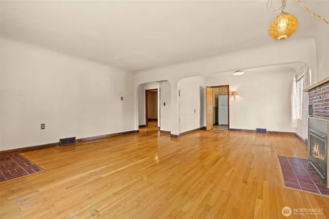 a view of an empty room with wooden floor and cabinet