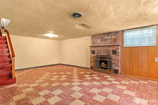 a view of empty room with fireplace and wooden floor